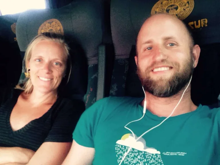 Selbstporträt einer lächelnden Frau und eines bärtigen Mannes im Reisebus