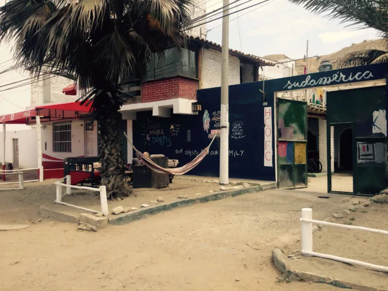 Strassenecke mit Hängematte und dunkelblauem Gebäude mit der Aufschrift Sudamerica